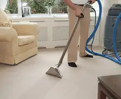 Carpet cleaning professional removing dirt and stains with a hot-water extraction tool in a home, Lakewood, CO.